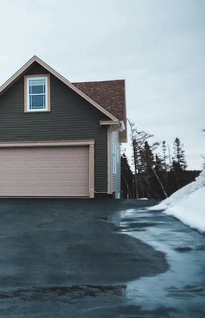 Asphalte résidentiel devant un garage double en hiver. Le scellant asphalte protège la structure contre les dommages causés par la glace et le sel.