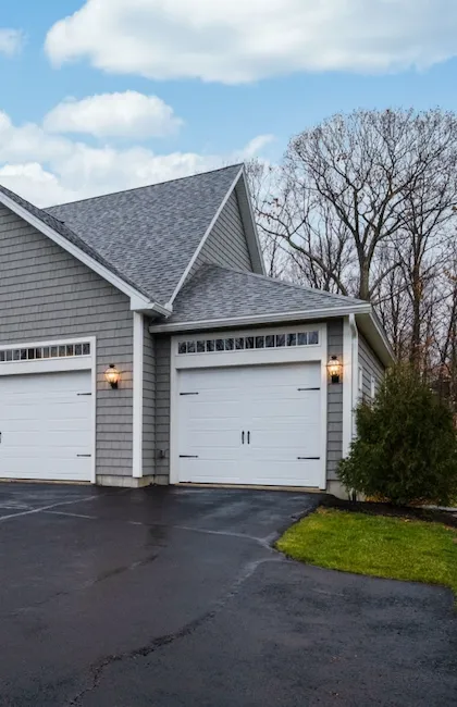 Vue de la section avant d'une maison résidentielle avec une nouvelle entrée en asphalte fraîchement pavée. Idéal pour une compagnie asphalte Gatineau spécialisée en réparation et maintenance.